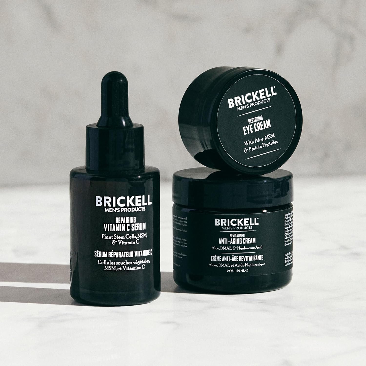 Vitamin C and peptide anti-aging skincare set for men including serum, night cream, and eye cream on minimal white background — view 3